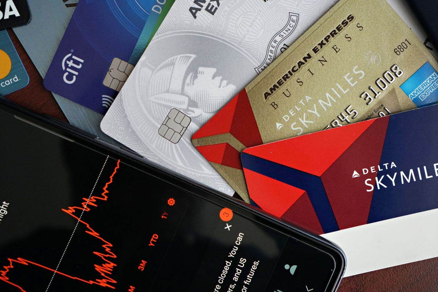 Payment cards next to a phone showing a banking app