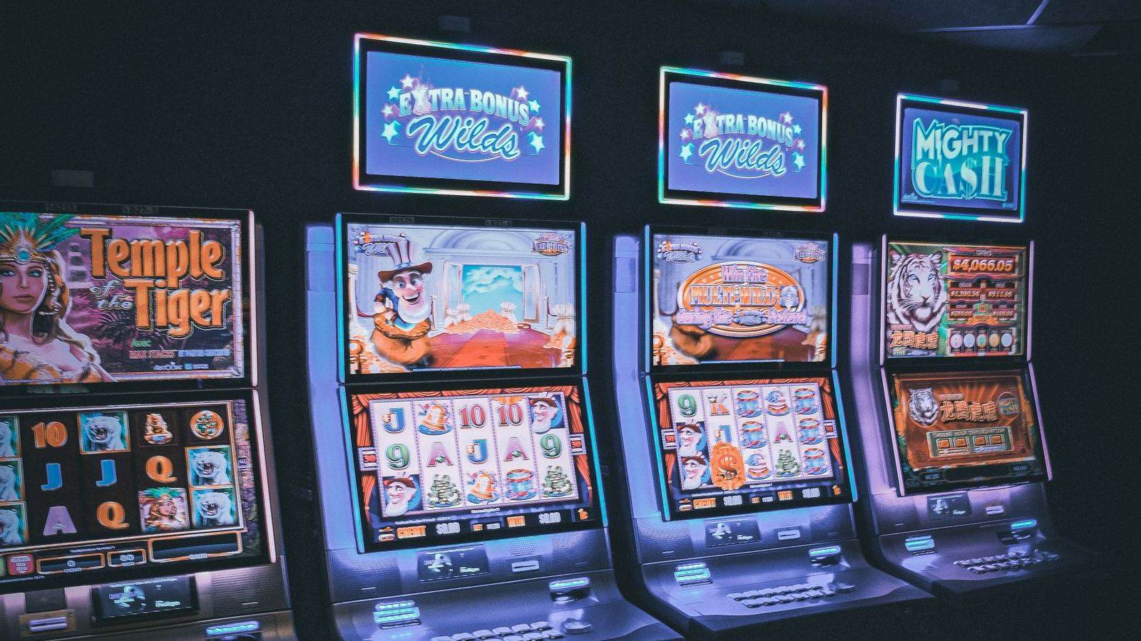Rows of glowing slot machines in a dark, empty casino