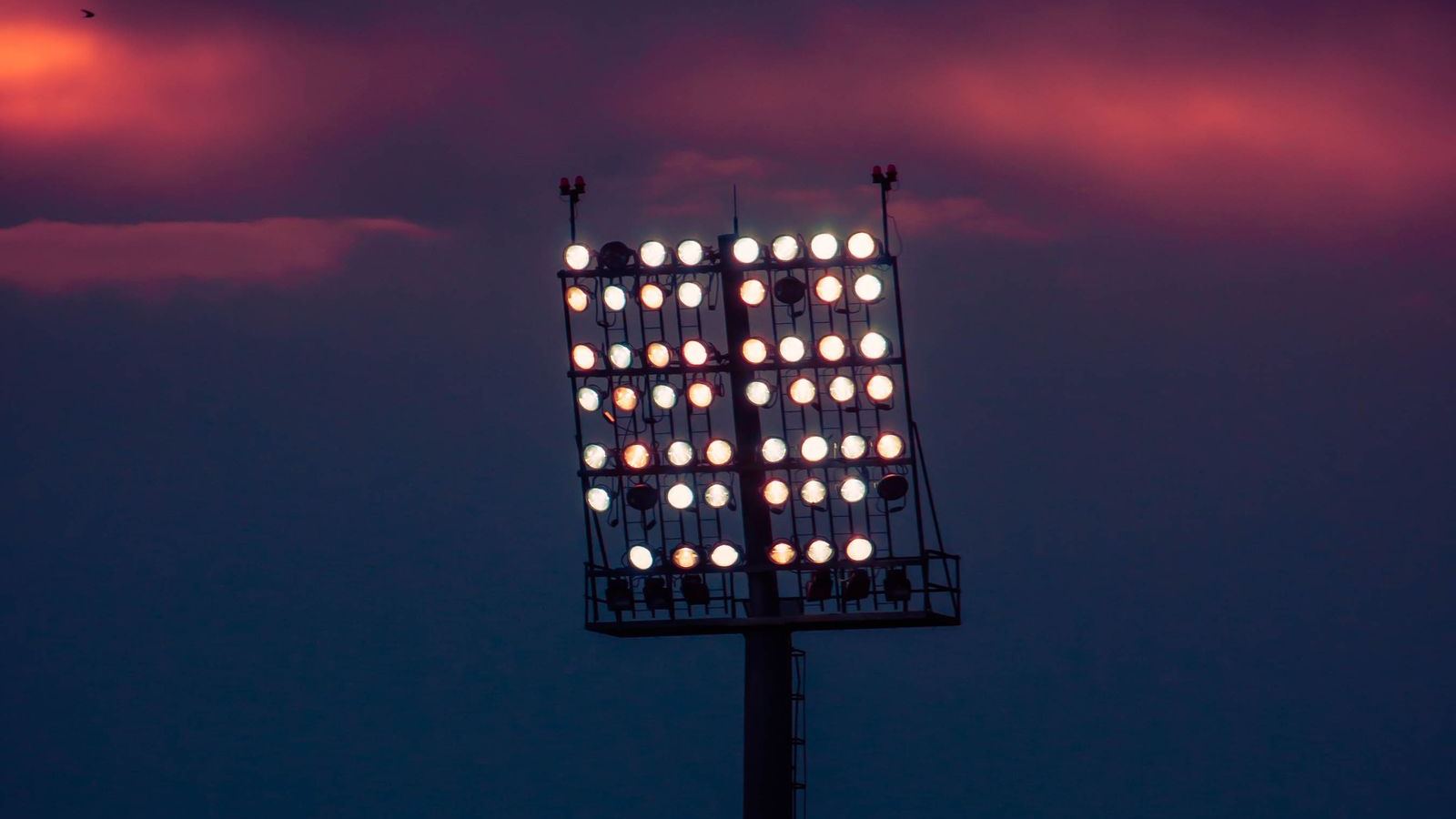 Stadium floodlights burning against a night sky
